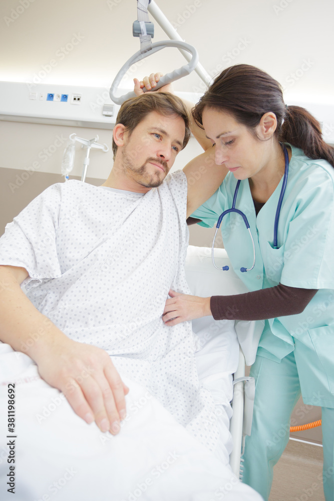 Obraz premium nurse adjusting hoist for patient in hospital