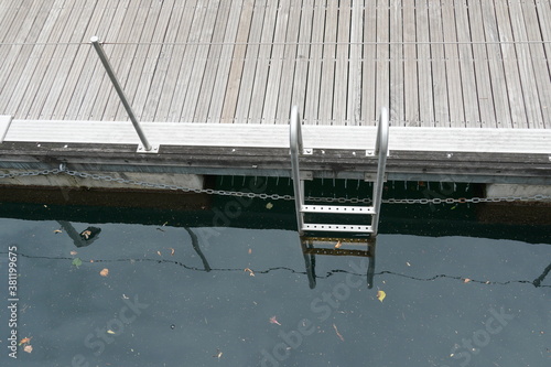 Billede på lærred Metal ladder for descending into the water in marina in Locarno, Switzerland