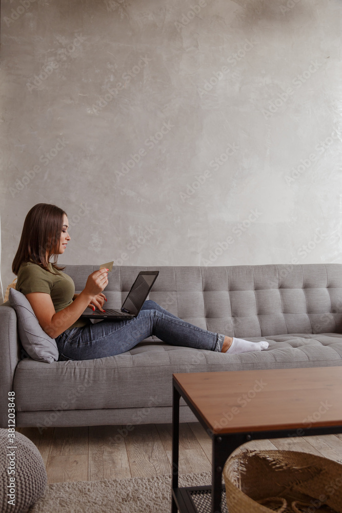 Young woman doing online payments with her credit card and laptop at home. Young woman doing online payments with her credit card and laptop at home.