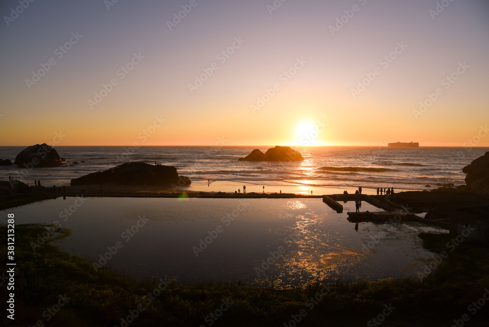 People are watching Sunset at the historical landmark Sutro Baths in San Francisco on the north side of Ocean Beach. And it's the trail head of Lands End.
