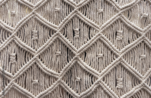 Macrame made of beige linen rope. Technique of knot weaving - macrame.