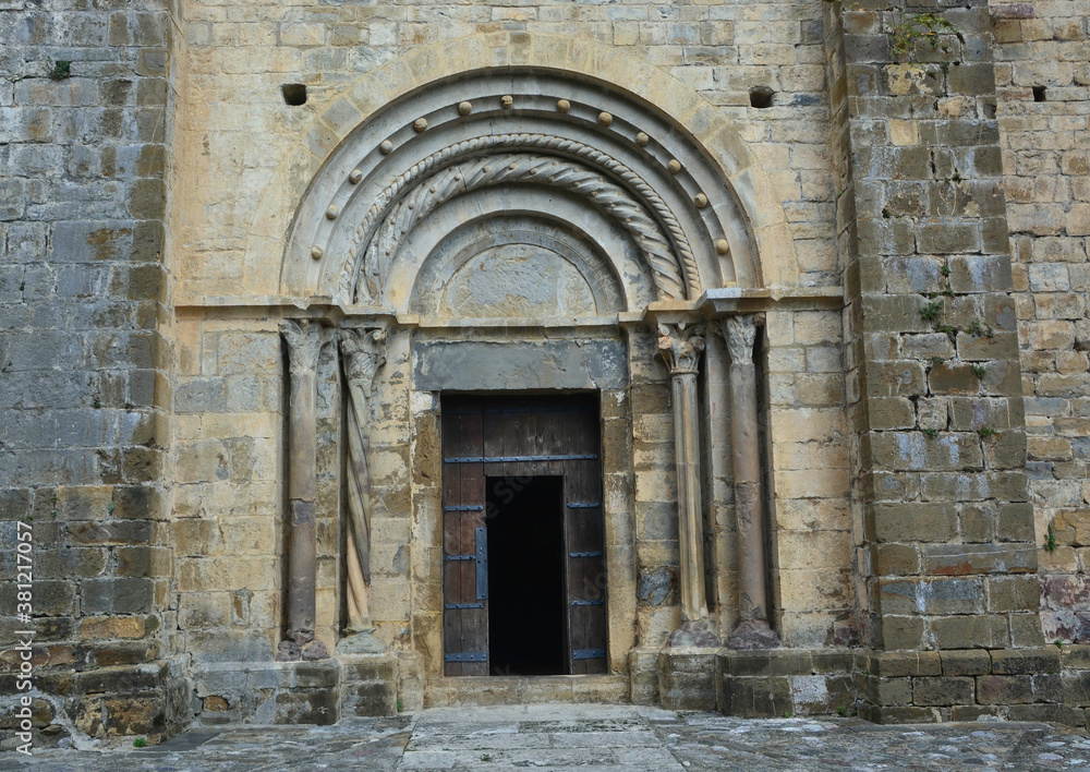 BEGET, CATALONIA, SPAIN, EUROPE, SEPTEMBER 2020. Fantastic main door of the Romanesque church of San Cristóbal with columns on both sides and an upper arcade in the beautiful medieval town of Beget