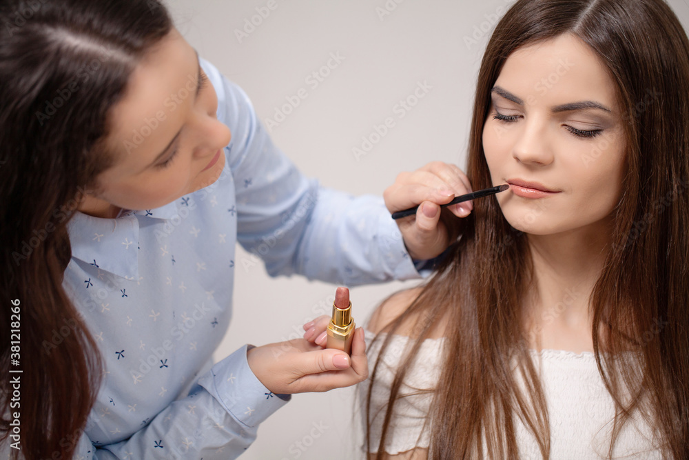 Make up artist doing professional make up of young woman Make up artist doing professional make up of young woman