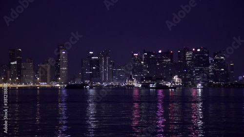 Lights of the night city of Singapore. Сity view from the sea. Financial district, office buildings, marina, city architecture, towers.