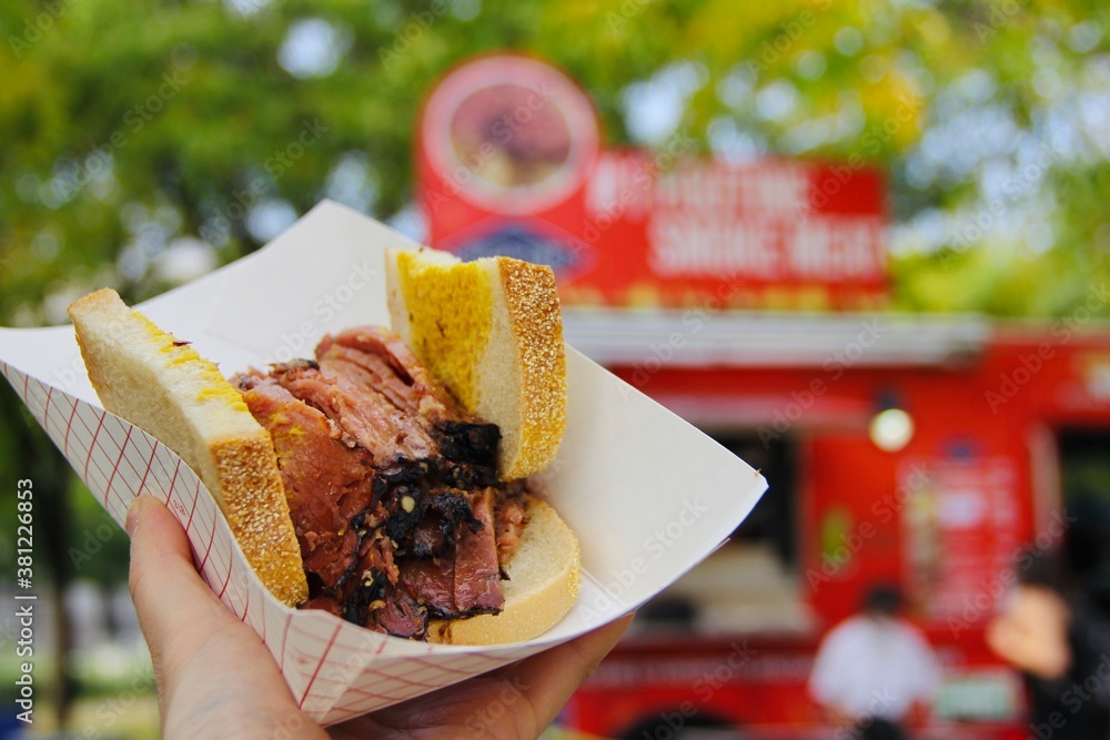 Obraz premium Trying popular street food in Montreal: Smoked meat sandwich (closeup)
