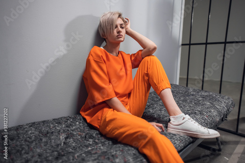 Canvas-taulu Girl convicted drug dealer in an orange jumpsuit in his cell on a prison bunk