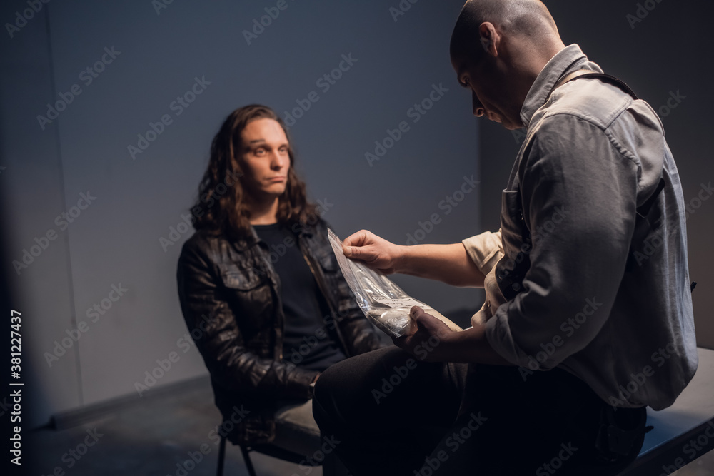 In the interview room, a handcuffed suspect meets with a police or FBI detective investigator without a lawyer In the interview room, a handcuffed suspect meets with a police or FBI detective investigator without a lawyer