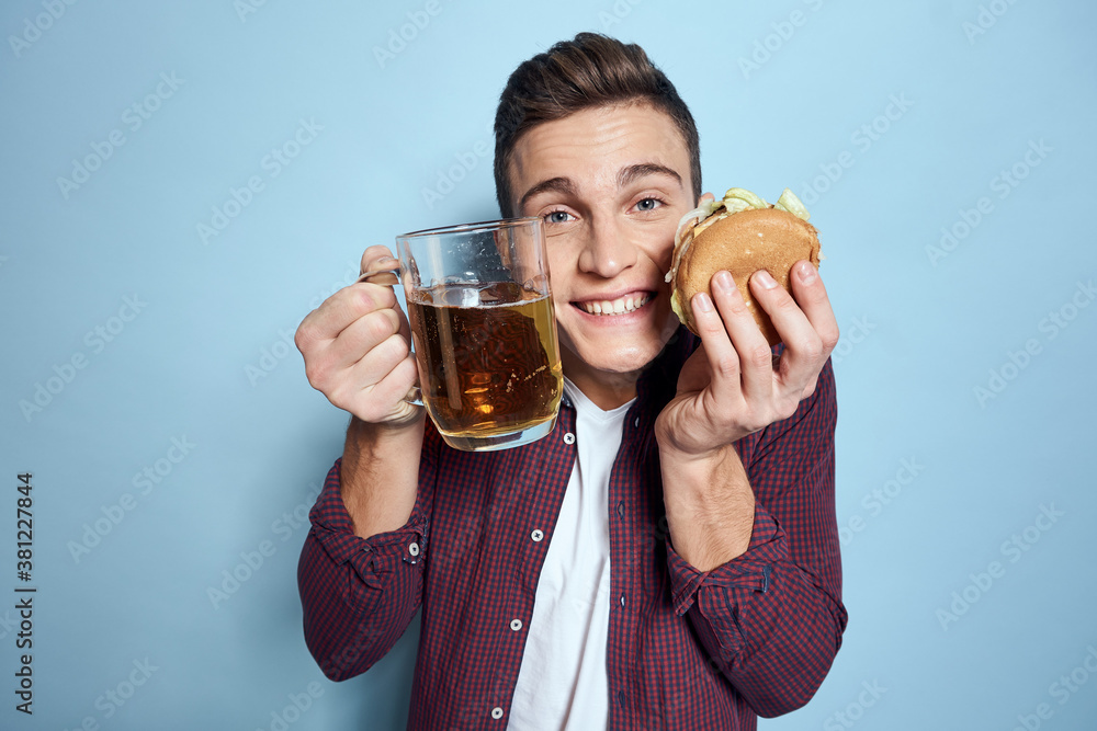 cheerful drunk man with beer mug and hamburger in hand diet food lifestyle blue background cheerful drunk man with beer mug and hamburger in hand diet food lifestyle blue background