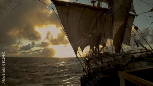 Sailing vessel.  Wind-filled sails.  At sunrise.  Silhouette. Freedom. Ocean.