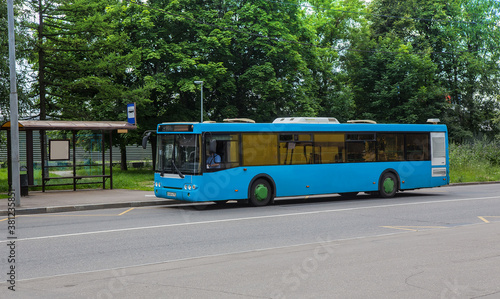 Regular bus at a stop on the background of a summer day