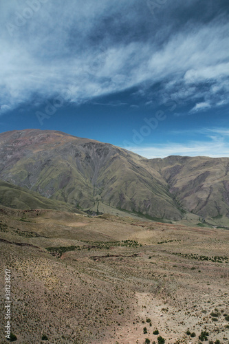 View of the popular landmark Bishop s slope in the Andes mountain range. The green field leading to the beautiful textured hills under a blue sky. 