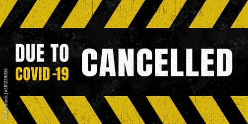 Grungy sign with text „cancelled - due to covid-19“ on it.