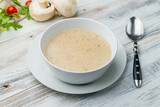 Cream soup of mushrooms on white wooden table