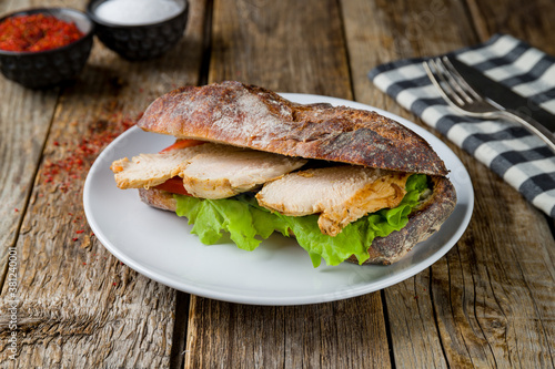 chicken breast and vegetable sandwich on old wooden table