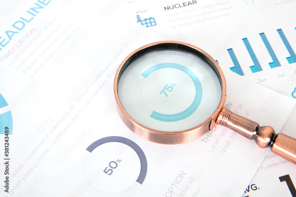 Financial information on a golden magnifying glass Financial information on a golden magnifying glass