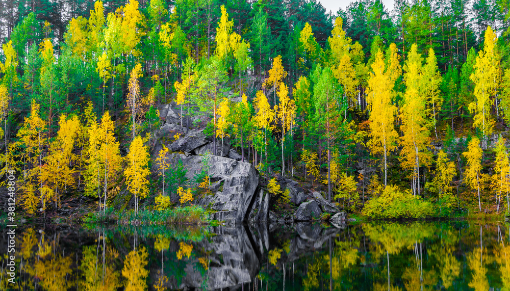 Lake in the mountains among the autumn forest.