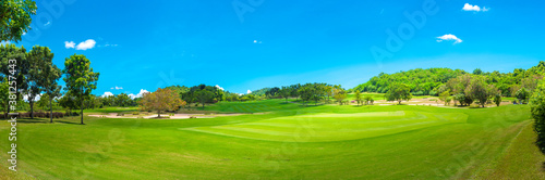 Fototapeta Naklejka Na Ścianę i Meble -  Beautiful green view at golf course ,green trees and mountain blue sky white cloud background