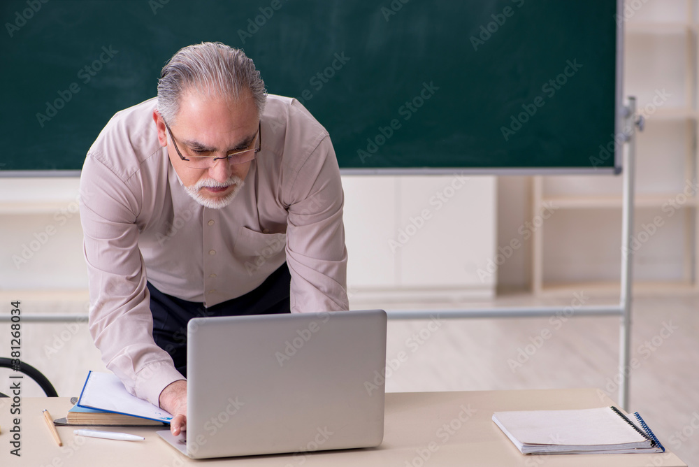 Old male teacher in the classroom Old male teacher in the classroom
