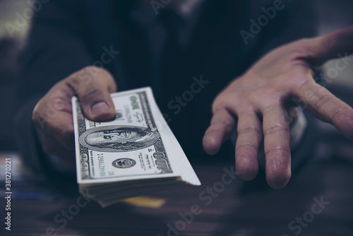 Bank teller man's hands giving dollar banknotes