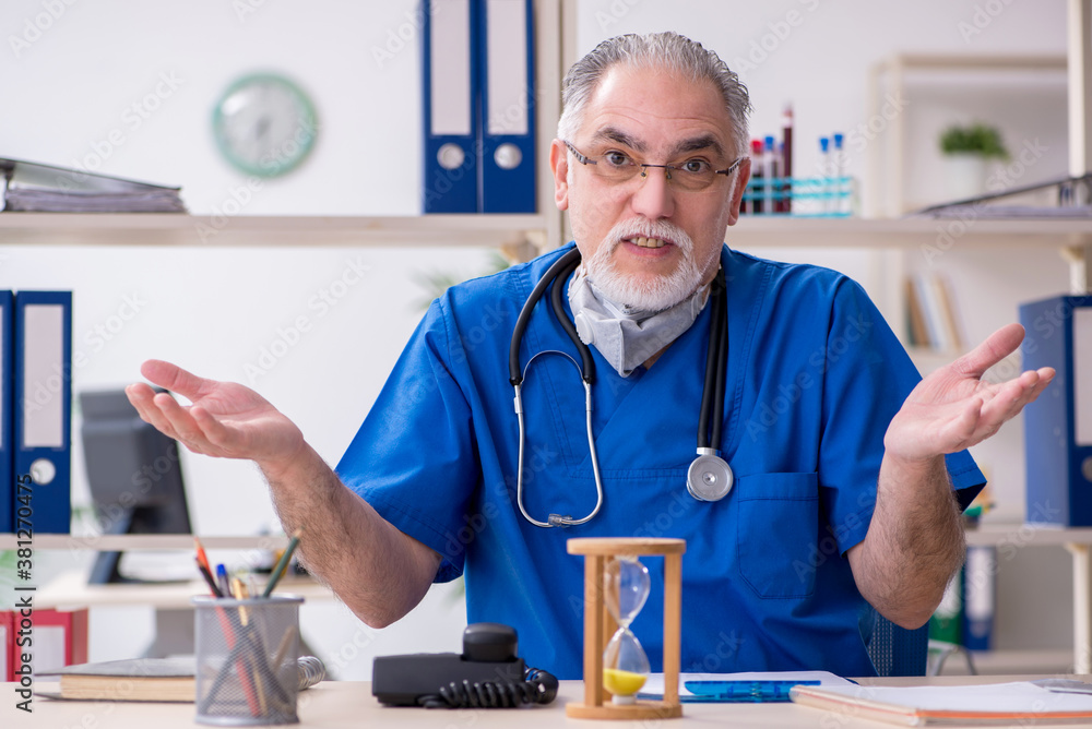 Old male doctor working in the clinic Old male doctor working in the clinic