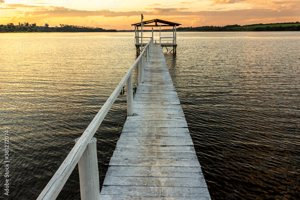 pier on the edge of a lake with sunset background in Brazil