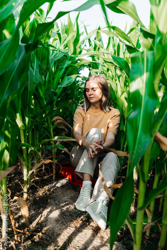 young woman in a corn field in a yellow t-shirt with a place under the text with short hair