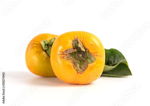 Fresh ripe persimmon with leaves isolated on white background. Healthy food concept