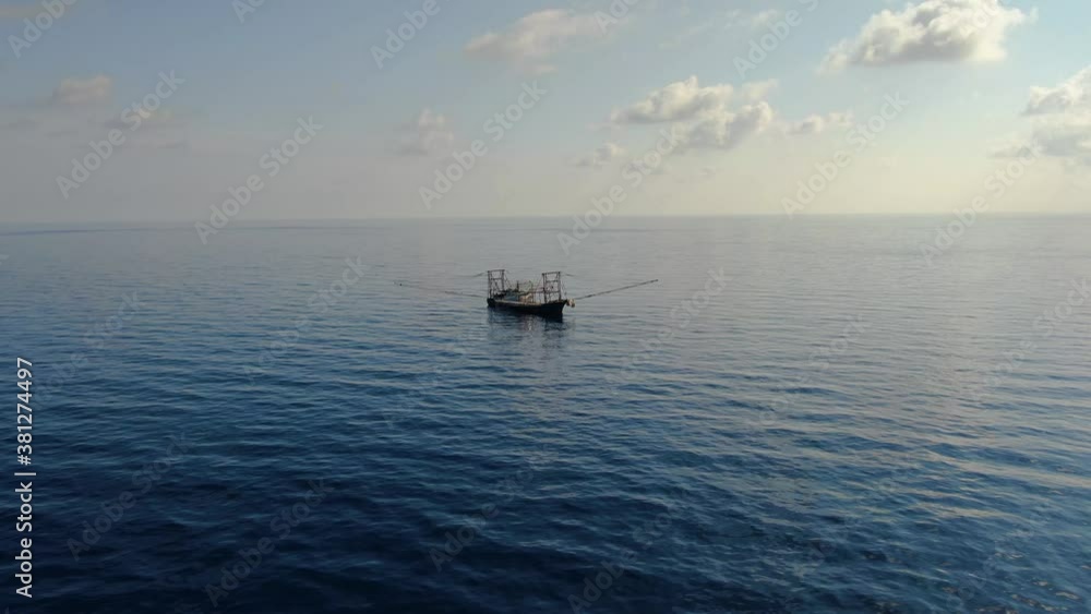 A fishing vessel catches fish in the open ocean. Aerial 4K shot.