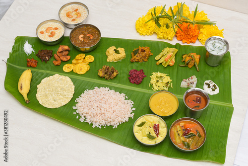 Traditional Onam sadhya, boiled rice, served for Kerala Indian festival  with curries Sambar, Rasam, Pulisseri, Avial, Thoran, Papadum, Payasam, Banana, Yogurt or Buttermilk, chips