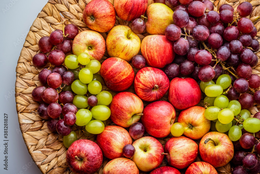 Red apples and grapes on a wicker dish. Red apples and grapes on a wicker dish.