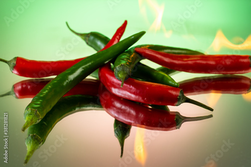 hot red and green peppers burning in chili fire on gradient background