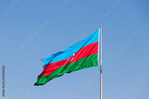 Azerbaijan Flag against blue sky. National flag of Azerbaijan on strong wind in the sunny day