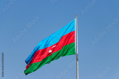 Azerbaijan Flag against blue sky. National flag of Azerbaijan on strong wind in the sunny day