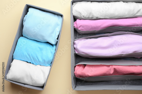 Organizers with clean clothes on color background