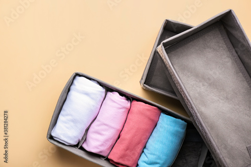 Organizers with clean clothes on color background