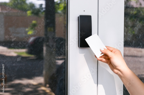 Tablou pe pânză Woman using card to open door outdoors
