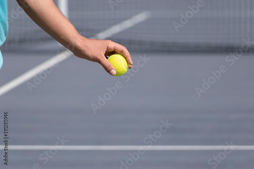 Tennis player on hard tennis court prepares to serve. Start of the game concept. Sports background with copy space. Selective focus