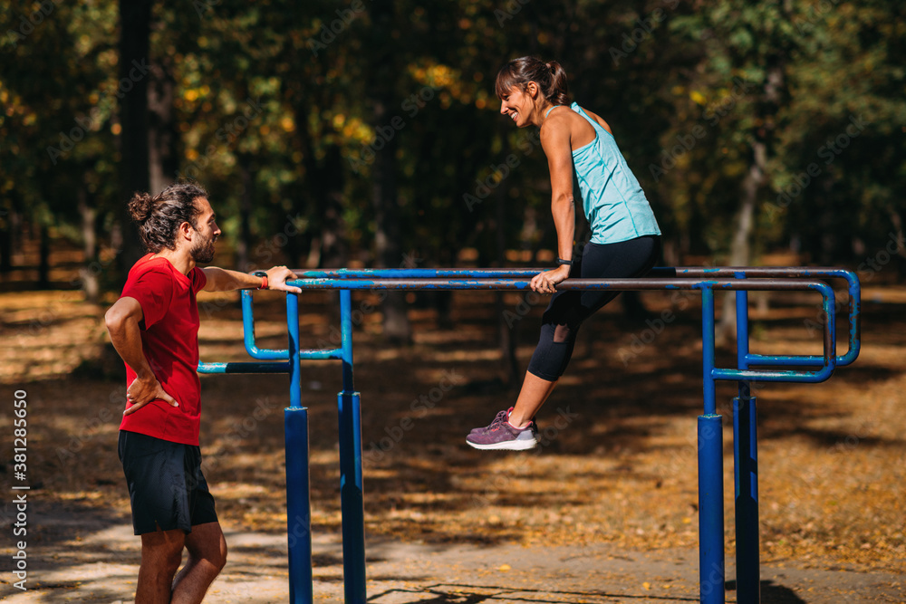 Fototapeta premium Exercising on parallel bar in the park