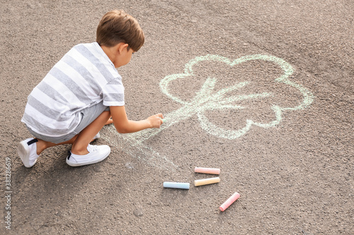 Little boy drawing tree wit...