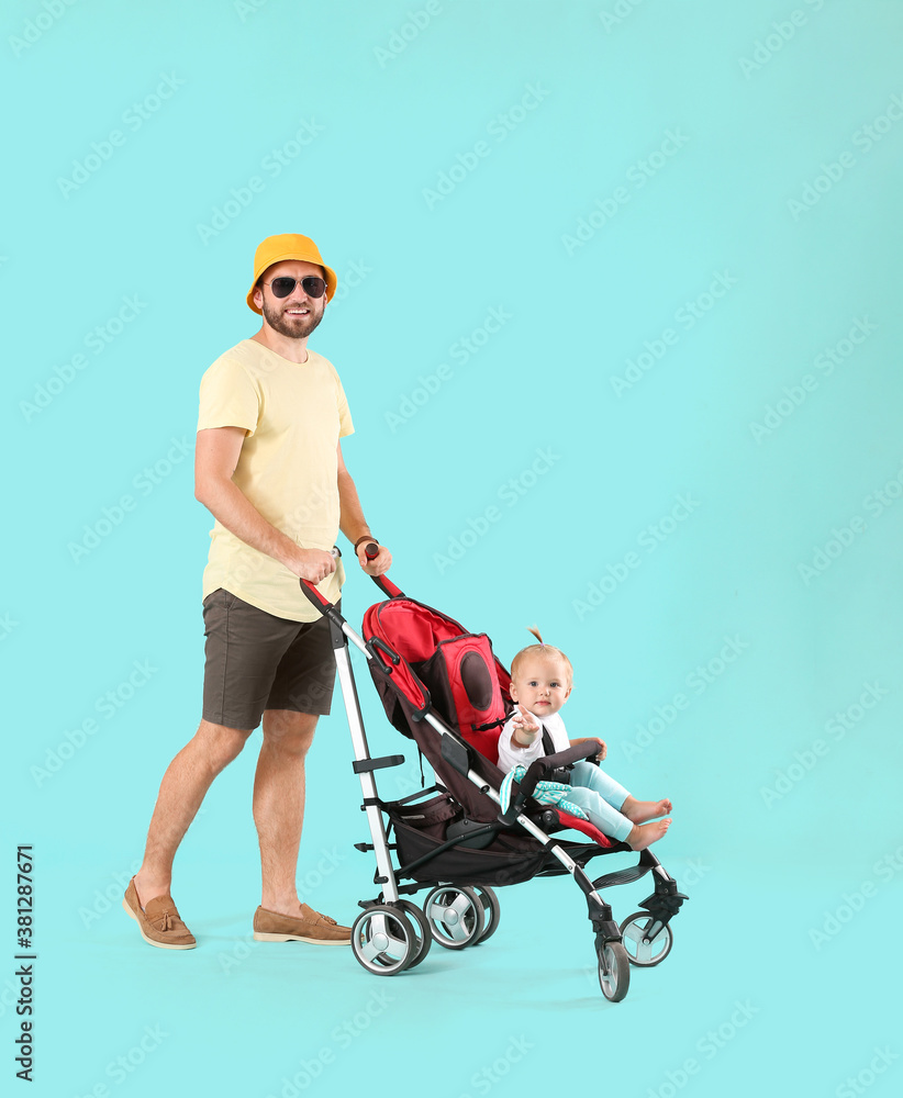 Father and his cute baby in stroller on color background Father and his cute baby in stroller on color background