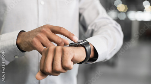 Businessman using smart watch in office, Closeup of young man hand touching device screen, Business, communication, technology concept