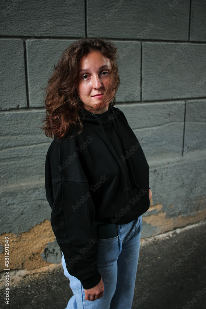 Young woman in black hoodie and jeans