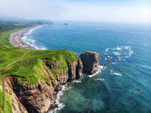 Green beautiful rocks of Kamchatka against the background of the bright blue sky.