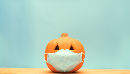 October break pumpkin.Halloween facial mask as a jack o lantern pumpkin wearing a medical face mask protection virus infection coronavirus covid-19.Happy halloween trick or treat.New normal.