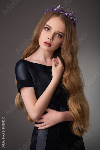 beautiful teen blonde girl with exquisite makeup in a stylish black dress