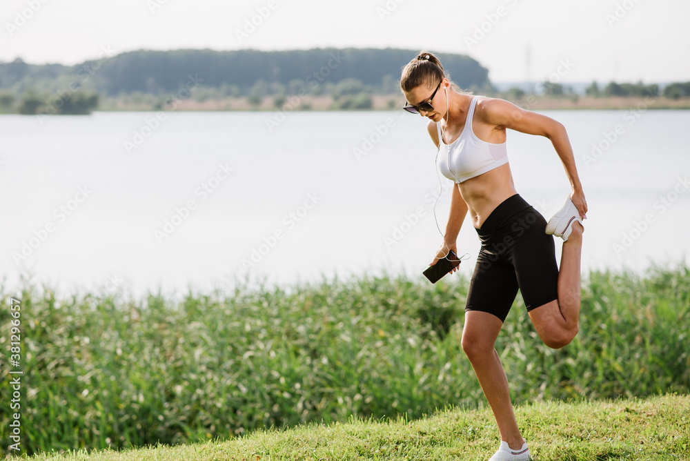 Young slim fit woman doing sport exercise outdoors in the park at the sunny day Young slim fit woman doing sport exercise outdoors in the park at the sunny day