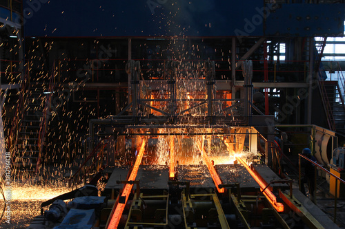 Red hot steel metal billets after molten steel casting.  Continuous casting machine. Background of the blacksmith and metallurgical industry.