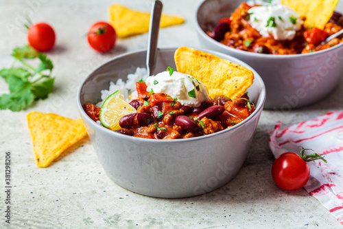 Slika na platnu Chili con carne with rice, sour cream and nachos in gray bowl