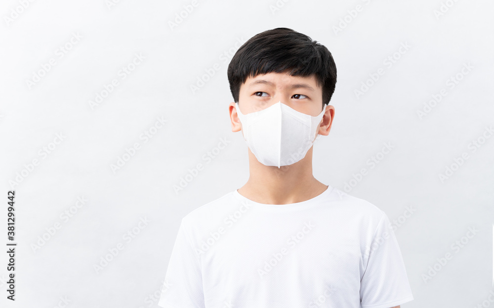 Studio portrait of a smart attractive young teenager asian boy in white t-shirt. He wearing a disposable face masks looking up as he hopeful that the pandemic will over soon. Covid-19, New normal. Studio portrait of a smart attractive young teenager asian boy in white t-shirt. He wearing a disposable face masks looking up as he hopeful that the pandemic will over soon. Covid-19, New normal.