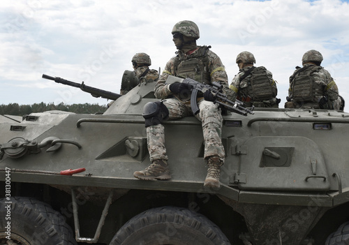 Obraz na plátne Soldiers with machine guns on an armored personnel carrier